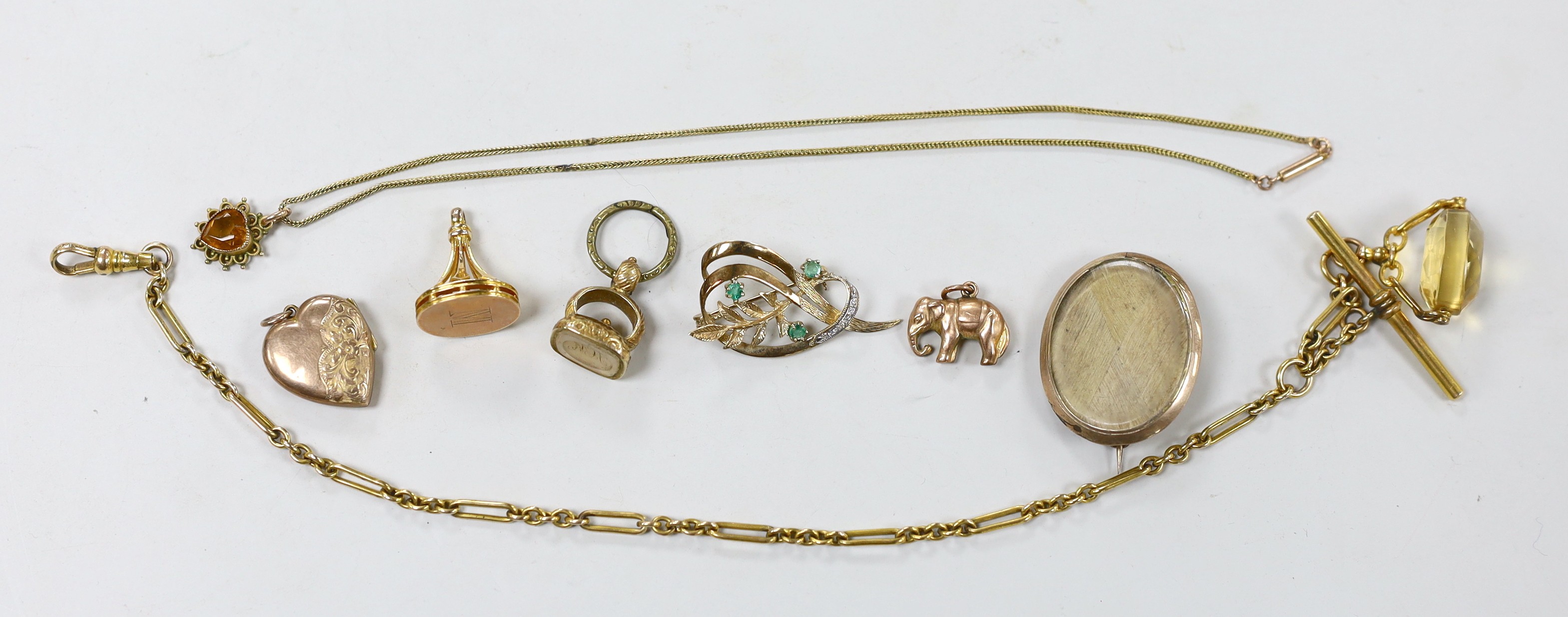 A small collection of Victorian and later jewellery, including two fob seals, two yellow metal charms, a 9ct pendant on a yellow metal chain, mourning pendant, gilt metal albert and a gem set yellow metal foliate brooch.